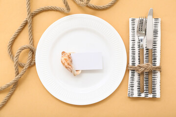 Beautiful table serving with marine decor and blank invitation card on beige background
