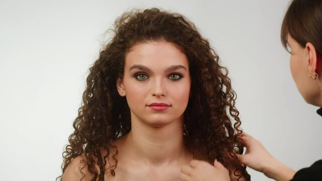 Beauty shot of woman makeup and hair artist doing hairstyle. Using hairspray for hair close-up.Concept of skincare, cosmetics, make up, beauty. Make-up and hair style tutorial 