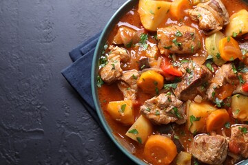 Delicious stew with vegetables on black table, top view