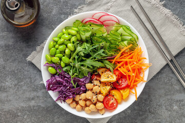 Buddha Bowl. Cucumber, carrot, arugula, red cabbage, edamame beans and sesame seeds. The concept of delicious balanced and healthy food. Top view