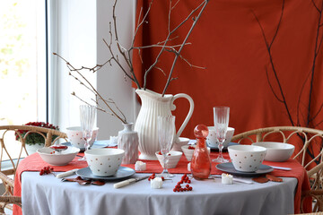 Autumn table setting with tree branches and berries in light dining room