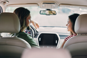 Young couple enjoying conversation in a car interior, showcasing a relaxed atmosphere