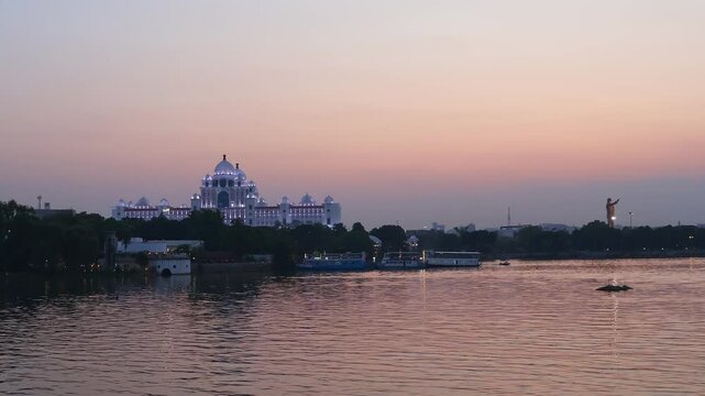 Beautiful view of Dr. B. R. Ambedkar Telangana State Secretariat and Hussain Sagar Lake at the sunset in Hyderabad, India. Time lapse motion video.