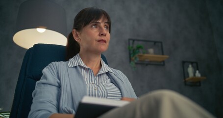 Close up of professional therapist sitting in chair, listening attentively to patient, taking notes...