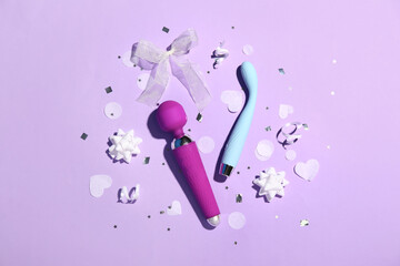 Composition with vibrators, gift bows and confetti on lilac background