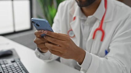 African american male doctor using smartphone in clinic office