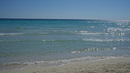 A scenic view of the clear turquoise mediterranean sea at porto cesareo beach in salento, puglia, italy on a sunny day.