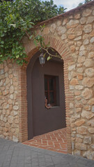 A senior woman peeks curiously through a rustic stone archway in a charming mediterranean alley.