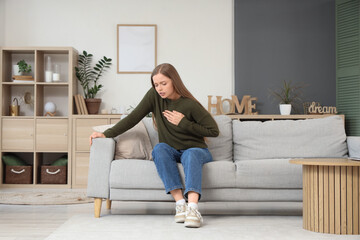 Young woman having panic attack on sofa at home
