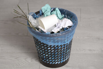 Trash bin full of garbage in kitchen