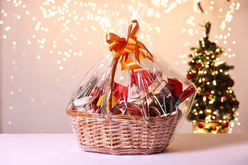 Wicker gift basket with wine on white table