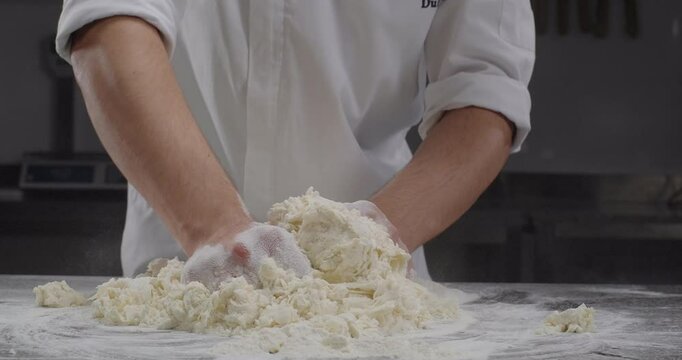 Chef knead dough with hands. Traditional phyllo dough recipe. Phyllo dough preparation