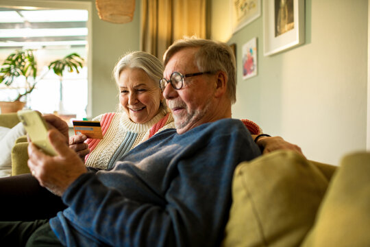 Senior couple shopping online together at home