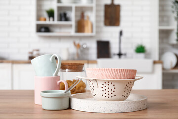 Bowls, cups and colander on wooden counter in kitchen