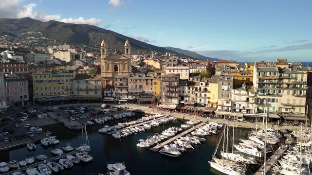Exploring the vibrant marina of Bastia, Corsica at dusk with stunning mountain views