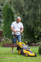 The banner. A lawn mower man mows the grass in the backyard. Agricultural machinery for garden maintenance.