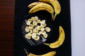 Banany i plasterki bananów na czarnym tle © Monika