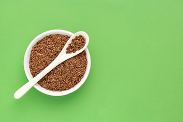 Organic Linum usitatissimum seeds in spoon and bowl - Flax seeds, healthy food.