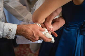 Fototapeta premium leg of newborn baby, baptism, held by parents, child, close-up, selective focus