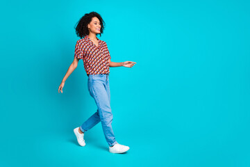 Profile side photo of good mood girl walking empty space isolated cyan color background