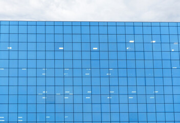 the facade of a modern building made of glass as a background, a reflection of the blue sky, a bank inscription