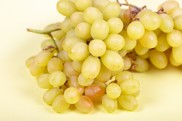 Fresh Green Grapes: Juicy Bunch of Sweet Table Grapes on Pale Yellow Background - Healthy Snack, Organic Produce, and Natural Fruit Photography