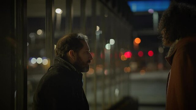 Drunk alcoholic man arguing with upset woman outside at night dispute