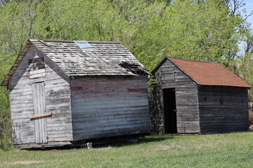 two abandoned wooden vintage farm buildings set aside