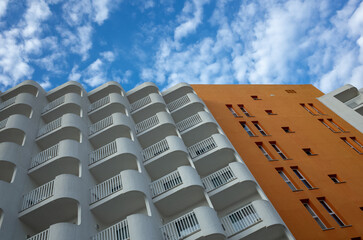 A tall building with a white facade and orange trim