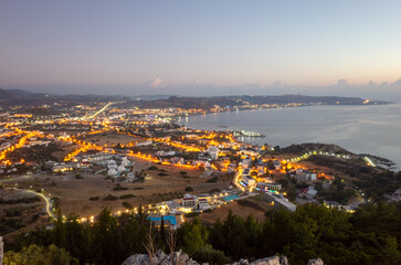 A city at night with a beautiful view of the ocean