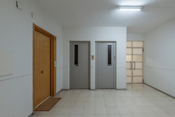 Common areas of a building with access to several elevators and stairs leading down