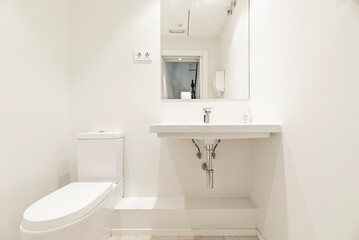 Neutral colors such as white, gray, and beige are used, often combined with materials such as glass, ceramic, and metal