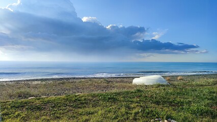 a lonely boat on the cold sea in sunny weather. when summer ended, cloud over the sea