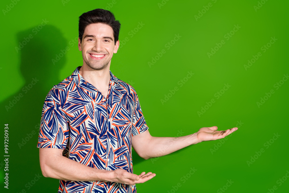 Canvas Prints Photo of good mood guy with stylish haircut dressed print shirt hands demonstrate product empty space isolated on green color background