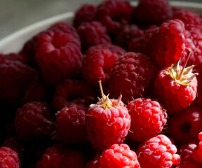 Close-up of fresh and ripe raspberries laying in a bowl. 