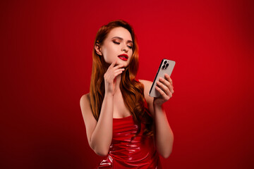 Photo of pretty stunning girl hold telephone eshop wear sexy leather outfit isolated on red color background