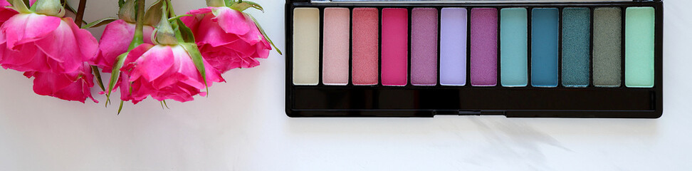 Eye shadows, curler, lipstick, cosmetic set on white background