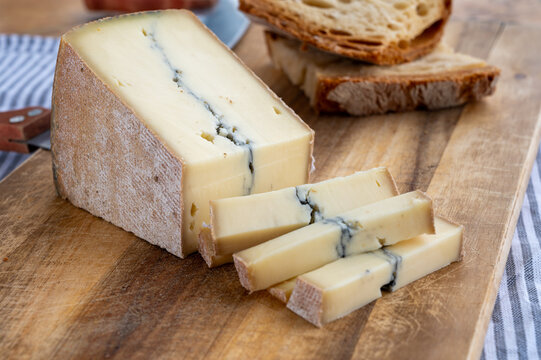 Cheese collection, French Morbier semi-soft cow milk cheese with black mold layer close up