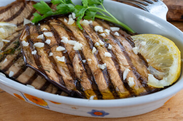 Italian style starter served in restaurant, grilled eggplant with garlic, olive oil and fresh parsley