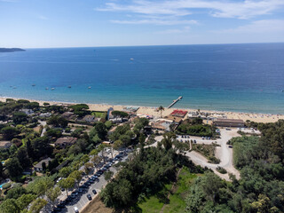 Fototapeta premium Aerial view on boats, crystal clear blue water of Plage du Debarquement white sandy beach near Cavalaire-sur-Mer and La Croix-Valmer, summer vacation on French Riviera, Var, France
