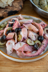 Tasty salad or starter seafood dish, grilled octopus ligurian style with green and black olives served in Italian  restaurant