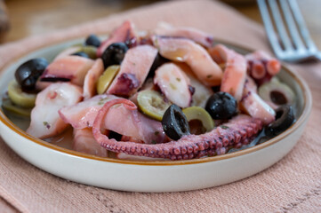 Tasty salad or starter seafood dish, grilled octopus ligurian style with green and black olives served in Italian  restaurant