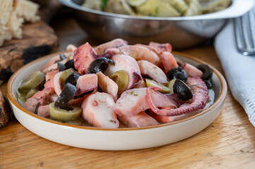 Tasty salad or starter seafood dish, grilled octopus ligurian style with green and black olives served in Italian  restaurant