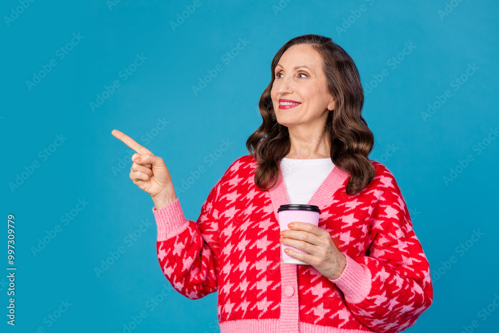 Poster Photo of nice pensioner female look point empty space hold coffee paper cup wear trendy pink print outfit isolated on blue color background