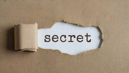 Torn Cardboard Revealing the Word "Secret" Signifying Concealment, Hidden Information, and Secrecy Underneath a Simple Exterior