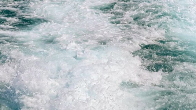 Slow motion close up footage of turbulent trail of water wake created behind a boat travelling on Mediterranean Sea near Ibiza, Spain