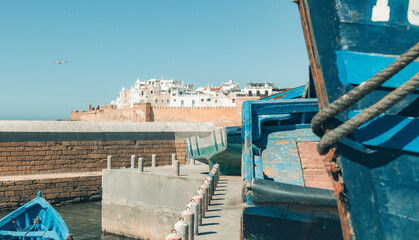 Ancient walled city of Essaouira with blue boats in famous port harbor, Essaouira, Morocco, coastal historic architecture, summer holiday scene, traditional dock, travel adventure tourism destination