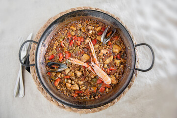 A top-down view of a traditional seafood paella served in a rustic pan, featuring shrimp, mussels, and mixed vegetables on a bed of saffron-infused rice,Mediterranean cuisine, Spanish food, 