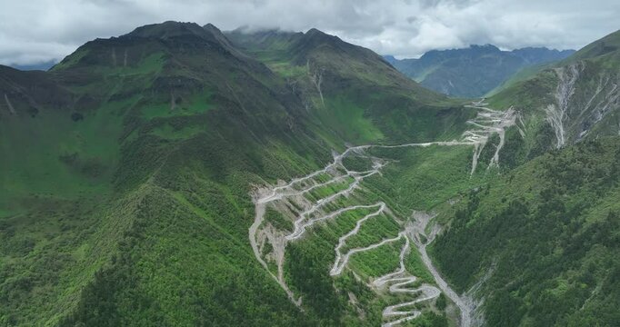 Aerial footage of beautiful high altitude snow capped mountain and grassland landscape
