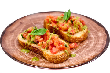 Traditional Italian appetizer,homemade bruscheta with tomatoes and basil served on brown plate, isolated on white background